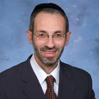 Headshot of Rabbi Moshe Barides smiling.