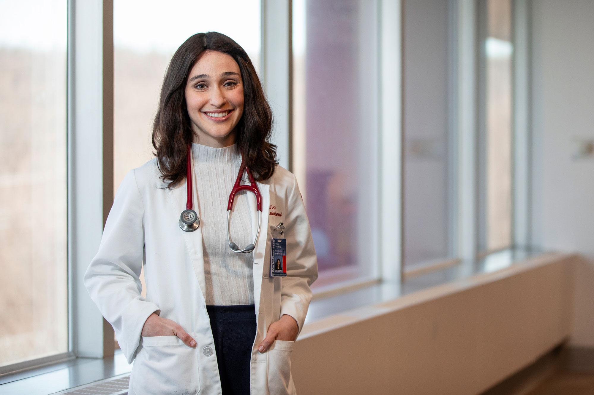 female student smiling while wearing scrubs