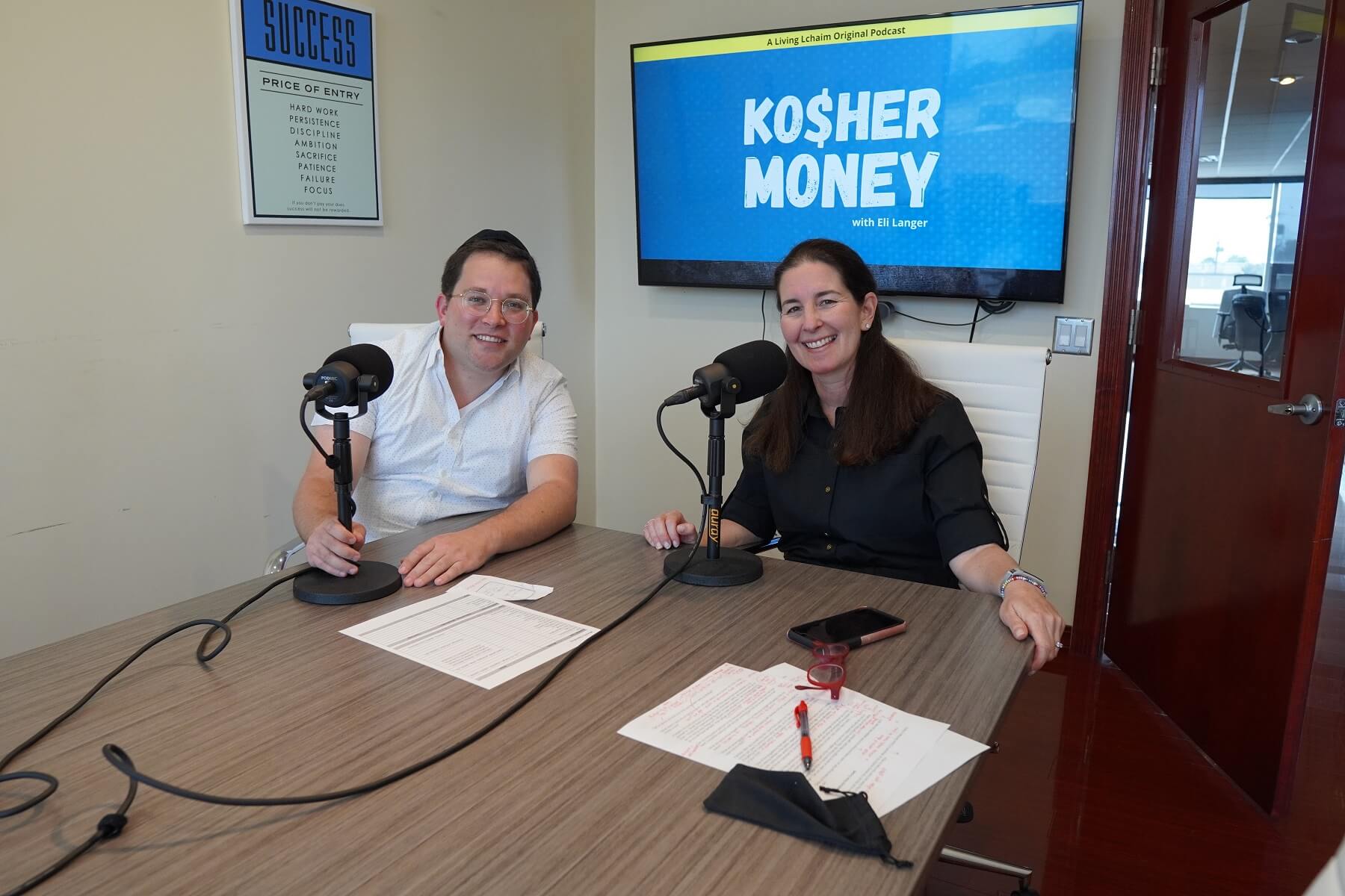 Touro alum Eli Langer sits by a desk with his female co-host of the podcast Kosher Money. 