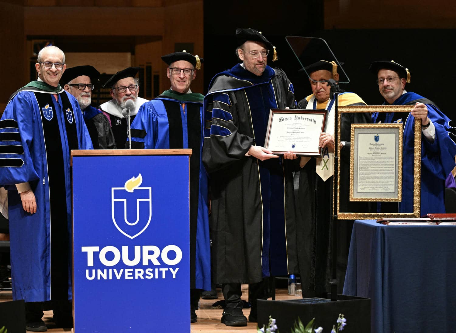 Members of Touro\'s senior leadership confer an honorary degree to Shlomo Yehuda Rechnitz at university&rsquo;s 52nd annual commencement exercises held on May 31 at Alice Tully Hall at Lincoln Center.